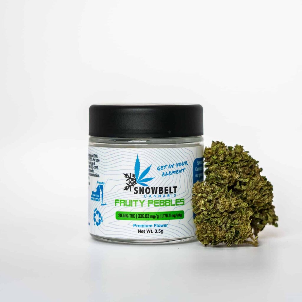 A jar labeled "Snowbelt Cannabis Fruity Pebbles Premium Flower" next to a dense green cannabis bud, against a plain white background. The label displays THC and CBG content and eco-friendly symbols.