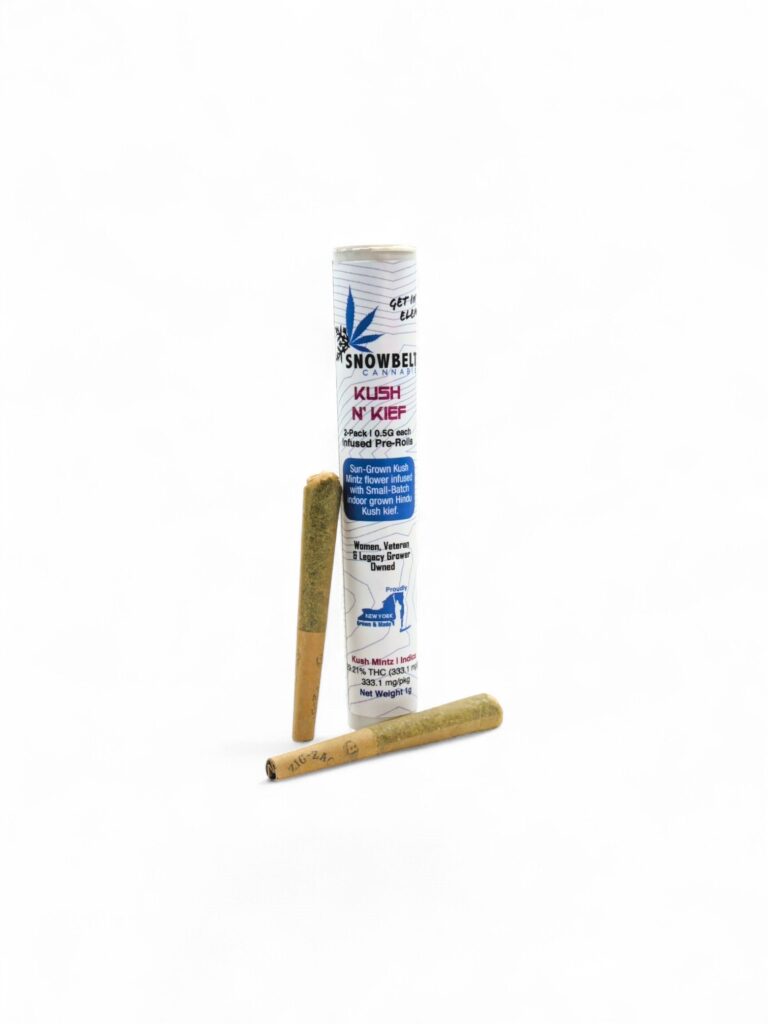 A cylindrical white container labeled "Snowbelt Kush N’ Kief" stands upright, with two pre-rolled cannabis joints—one leaning against the container and one lying in front—against a white background.