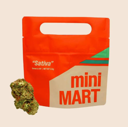 A red and beige resealable bag labeled "mini MART" and "Sativa" with green and orange accents, next to a small cluster of cannabis buds.