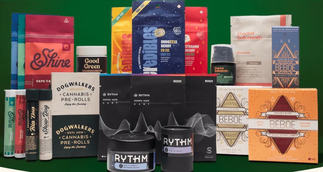 A variety of cannabis product packages, including pre-rolls, vape cartridges, edibles, and flower jars from brands like Rhythm, Beboe, Shine, and Dogwalkers, arranged on a green background.