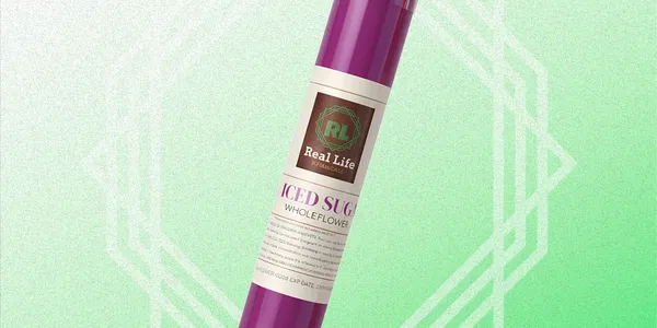 A purple tube labeled "Real Life Iced Sugar Wholeflower" stands upright against a green and white geometric gradient background.