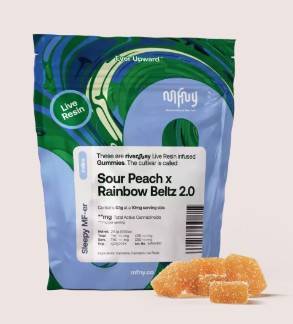 A blue and green resealable bag labeled "Sour Peach x Rainbow Beltz 2.0" gummies is shown upright, with orange gummy cubes placed in front of the bag. The packaging features modern graphics and product details.