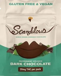 A hand holds a Scandalous peppermint crunch dark chocolate bar labeled gluten free, vegan, and 20mg THC.