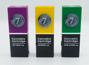 Three cannabis cartridge boxes in purple, yellow, and green packaging are displayed side by side.