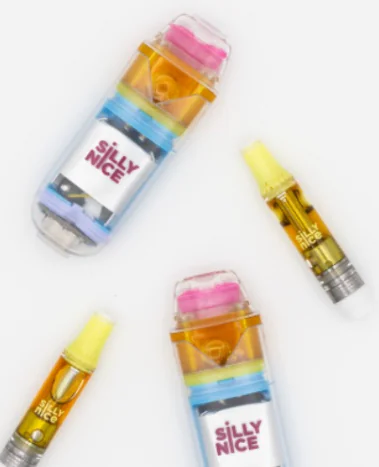 Three vape cartridges and two Silly Nice cannabis containers are neatly displayed on a white background.