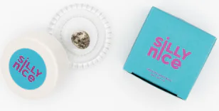 A small blue "Silly Nice" box sits beside a white round container holding a speckled item.