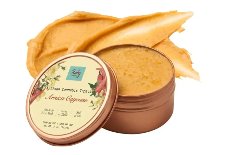 Open jar of arnica cayenne cannabis topical cream with some cream smeared behind the container.