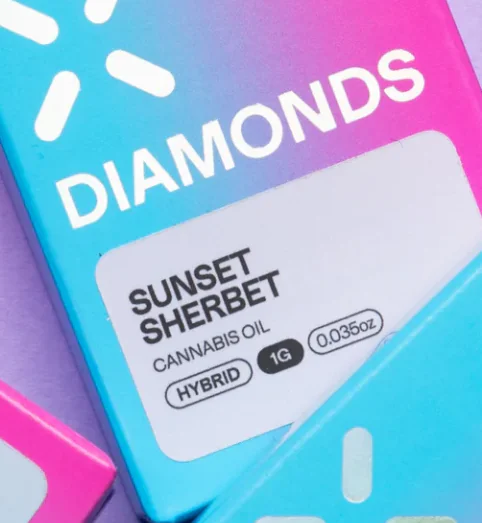 A colorful package displays DIAMONDS and SUNSET SHERBET CANNABIS OIL HYBRID 1G 0.035oz labeling.