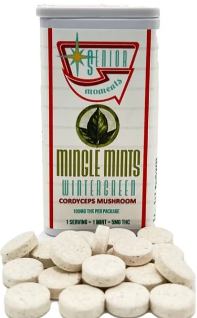 A container labeled “Mingle Mints Wintergreen” sits next to scattered white wintergreen mints.