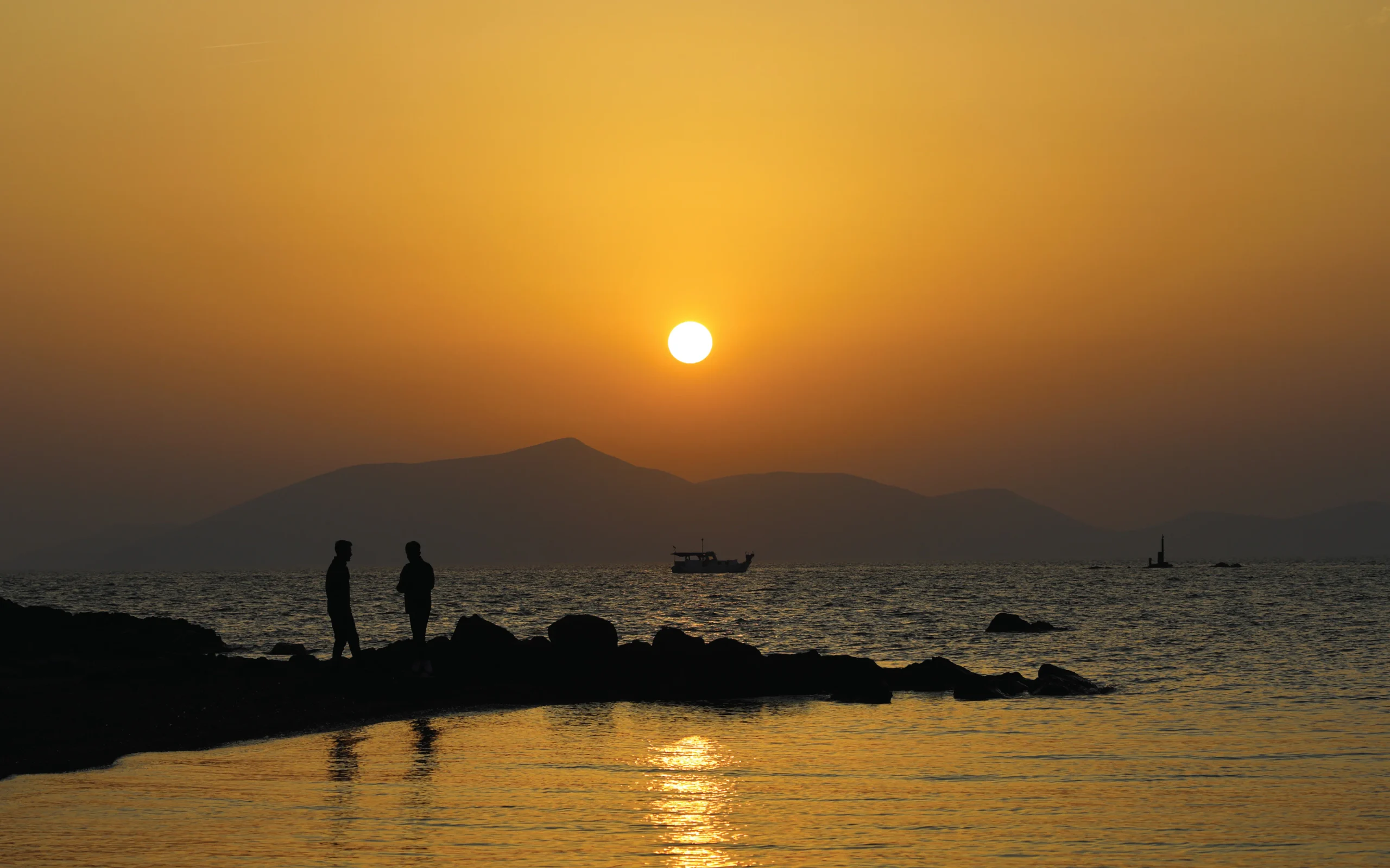 Friends watching a sunset over the water, Wyld lifestyle photo